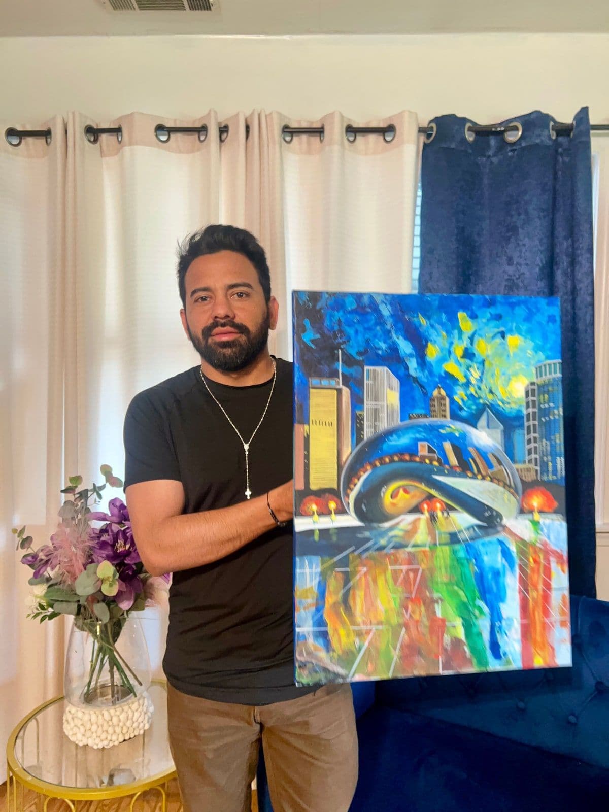 Alvir holding a painting of Chicago during his later practice in the United States.