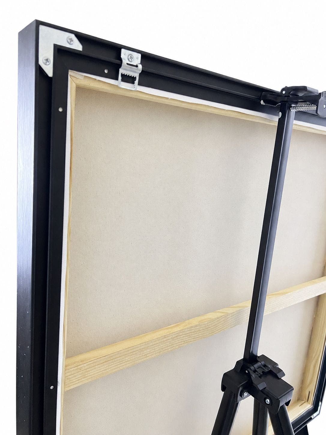 The back of the work: raw canvas over a pine stretcher, held in the black frame