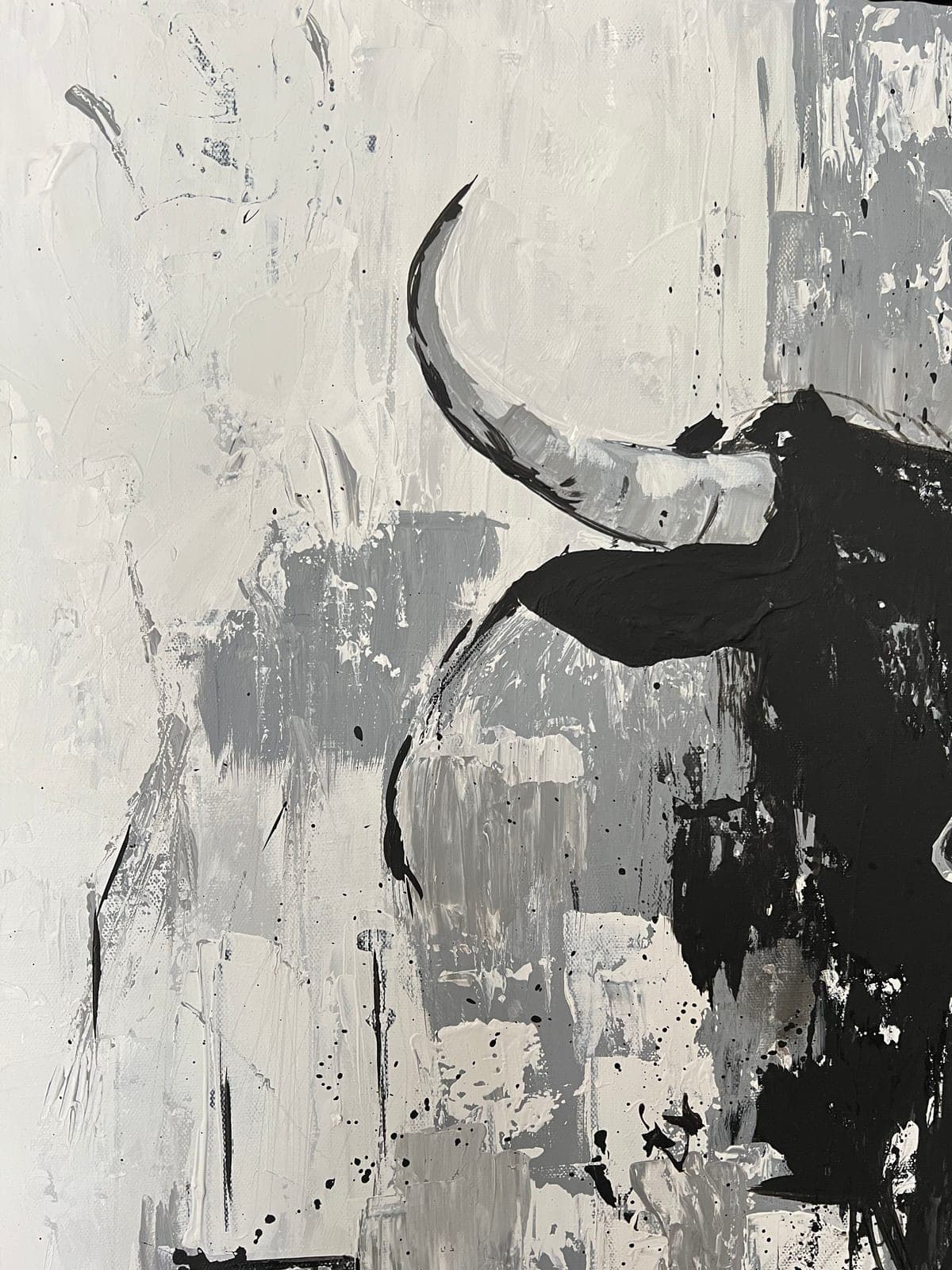 A single horn and the ear against the pale ground, black drips running down