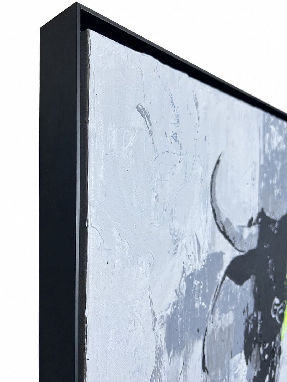 The top corner of the black floater frame, with the thick white ground and one horn behind it
